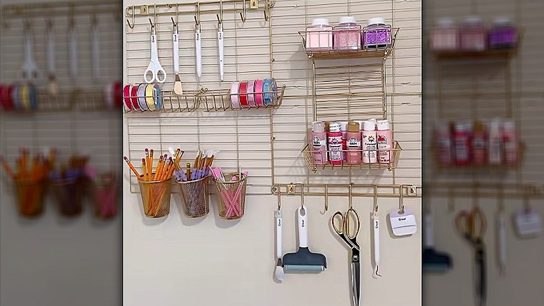 A DIY craft storage system based on four metal cooling racks and hung on the wall with craft supplies.