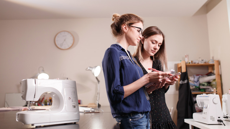 Two people standing in a craft room discussing organizational storage ideas.