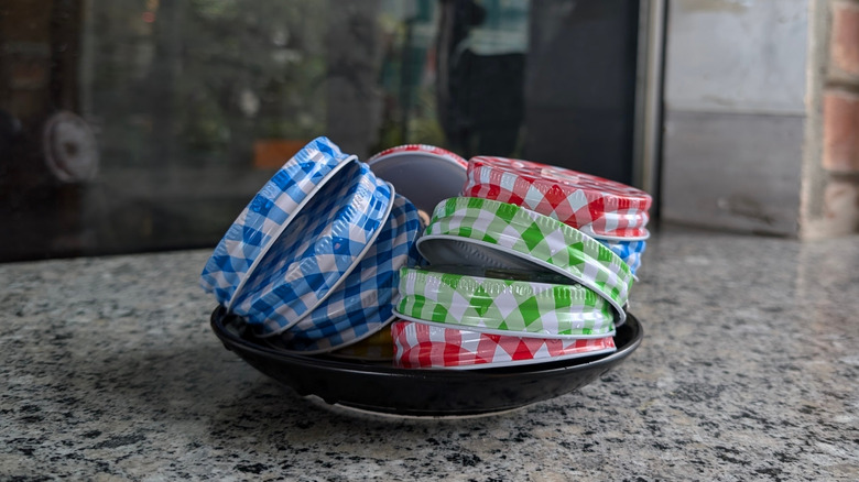 A collection of glass jar lids in a bowl on a countertop
