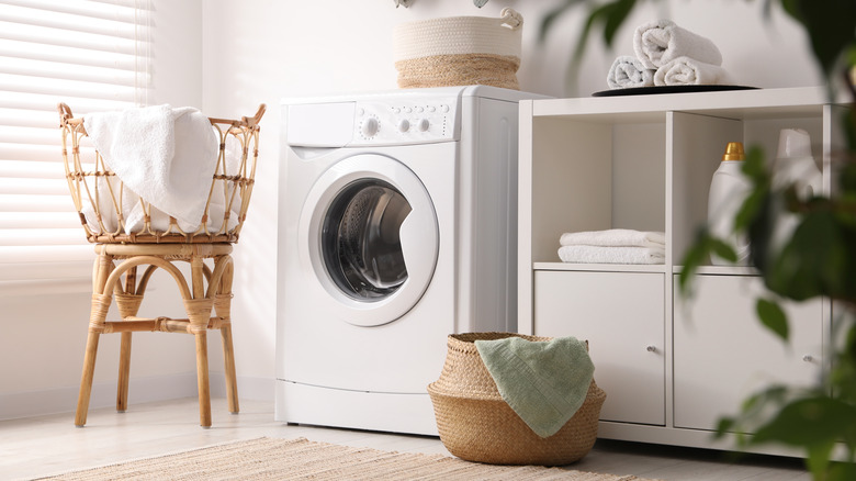 Laundry room with washing machine and cabinets