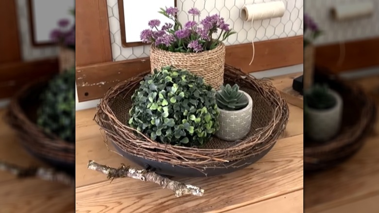 An upcycled pan is painted and decorated with natural fibers for use as a basket,