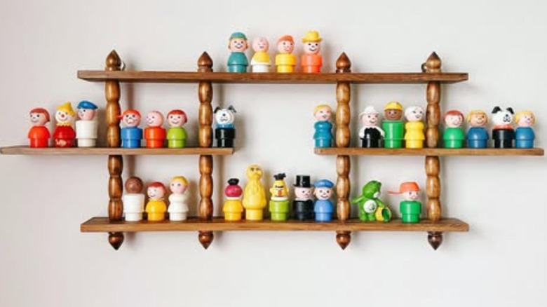 Fisher Price figures on wooden curio shelf