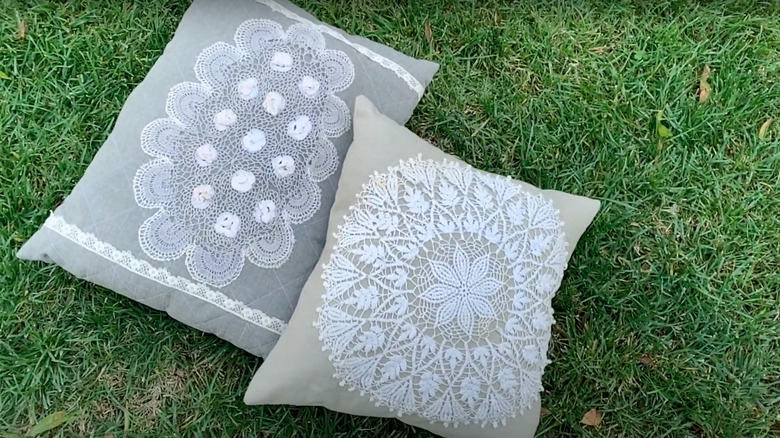 Doily throw pillows lying on grass
