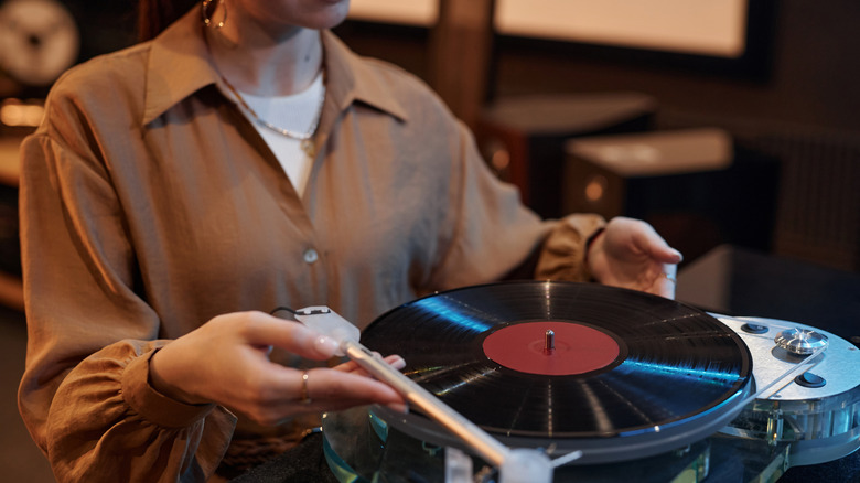A woman plays a vinyl record