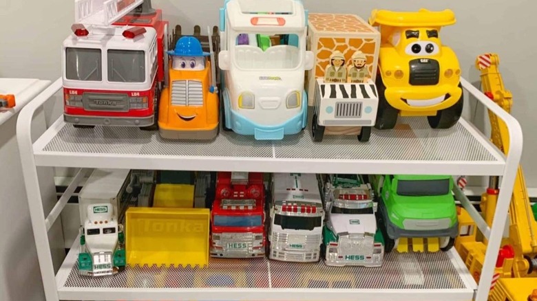 Toy trucks lined up on a two-tier shoe rack