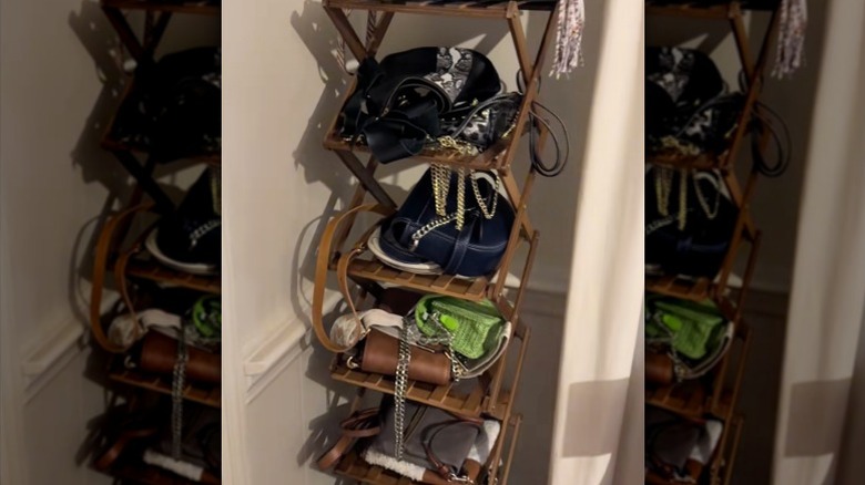 A shoe rack used to store small purses in the corner of a room.