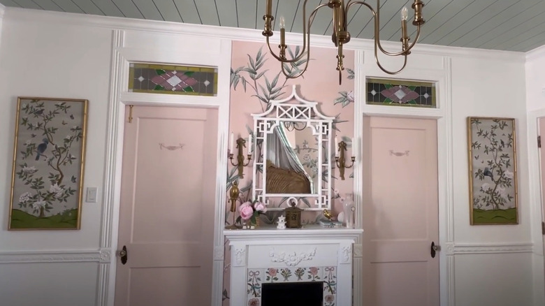An ornately decorated room with framed wallpaper on side walls