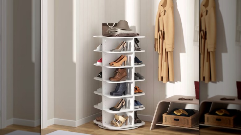 A tall rotating shoe rack full of shoes and displayed in the corner of an entryway.