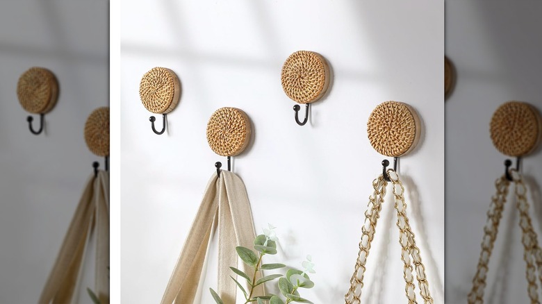 Rattan disc-topped hooks on a wall with bag straps hung from them