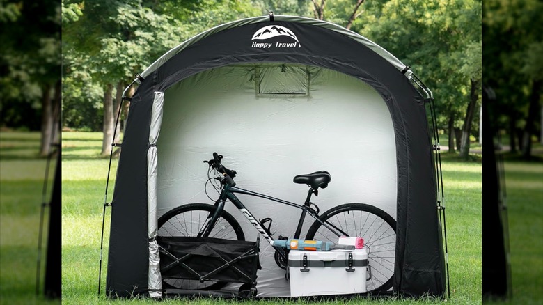 Happy Travel Bike Storage Shed Tent in a green field with a bike and cooler inside