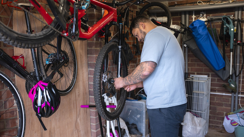 Man hanging bike in shed
