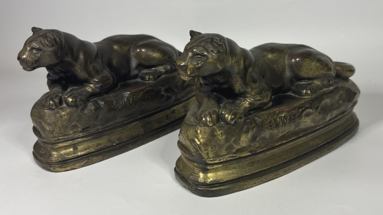 Two brass bookends featuring identical lions laying down