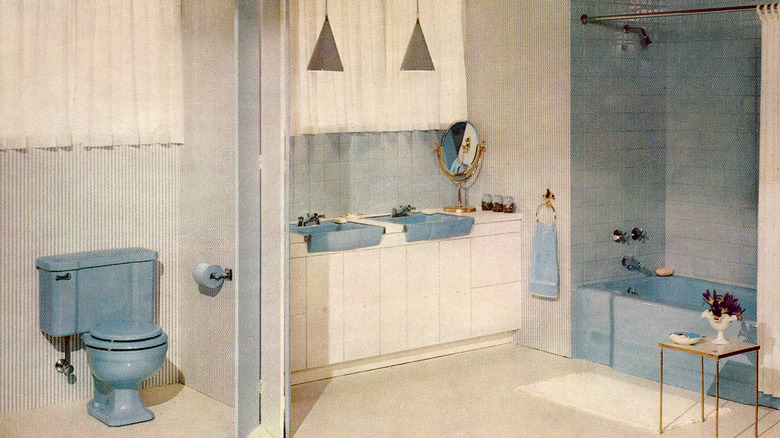A '50s bathroom with a blue toilet, tub, and sinks.