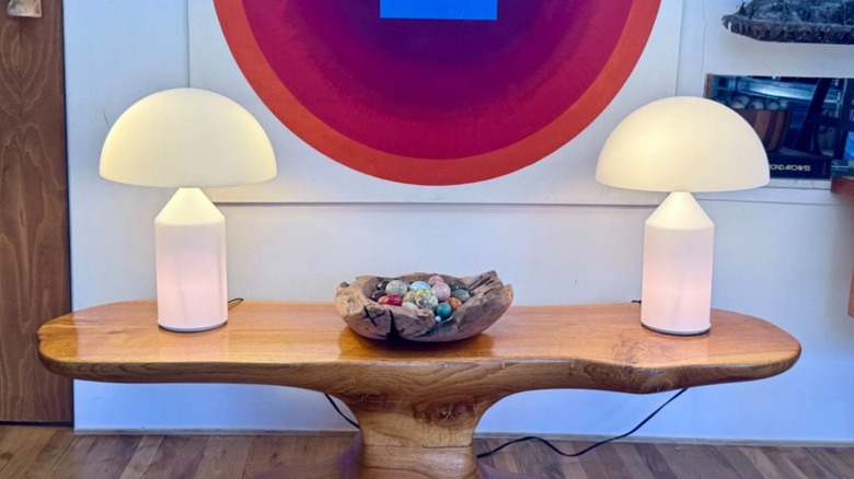 Two vintage Atollo opal glass lamps on a wooden table