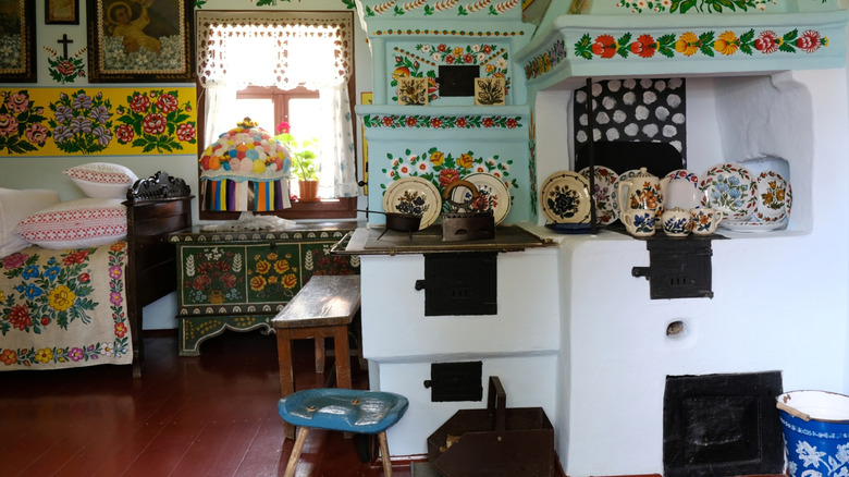 Room decorated with handpainted flowers, embroidered fabrics, and handmade furniture