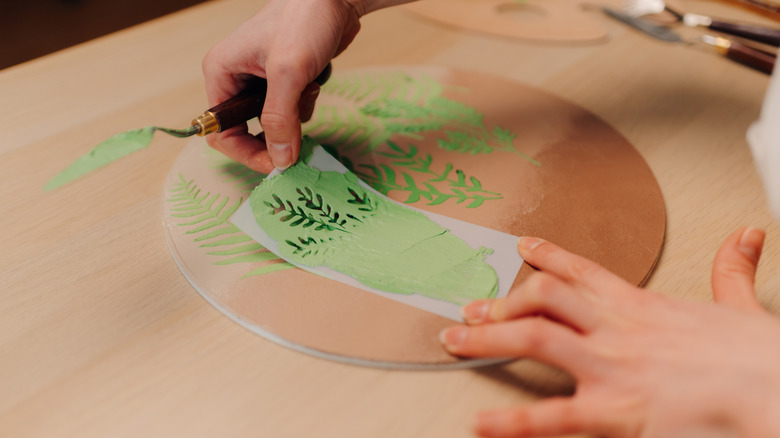 A crafter using a stencil to make an image