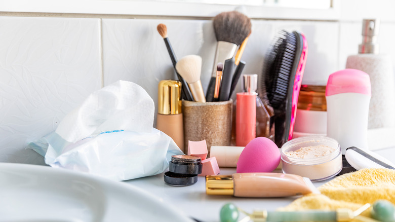 Disorganized beauty products scattered across a white counter
