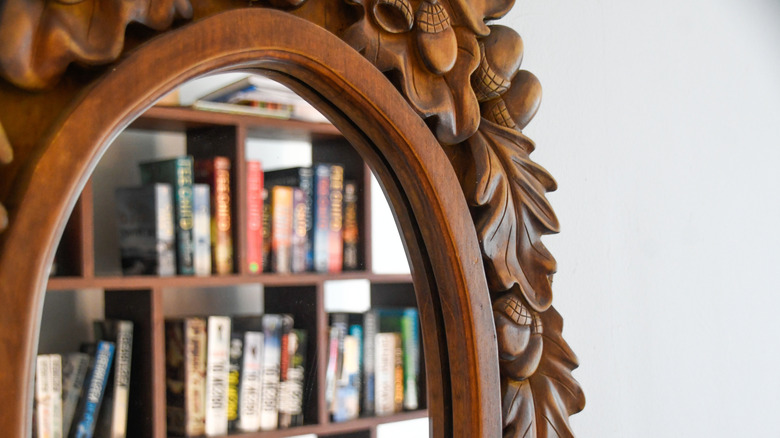 vintage mirror frame with a bookshelf reflection