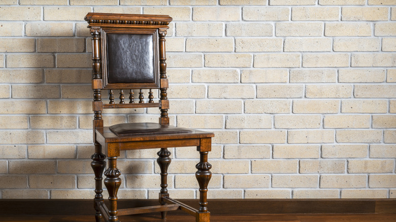Antique wooden chair by wall