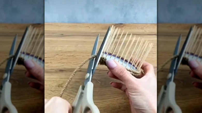 Person making a DIY mini plater using jar lid, toothpicks, and twine