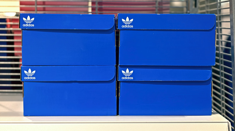 Four blue shoeboxes stacked on a shelf.