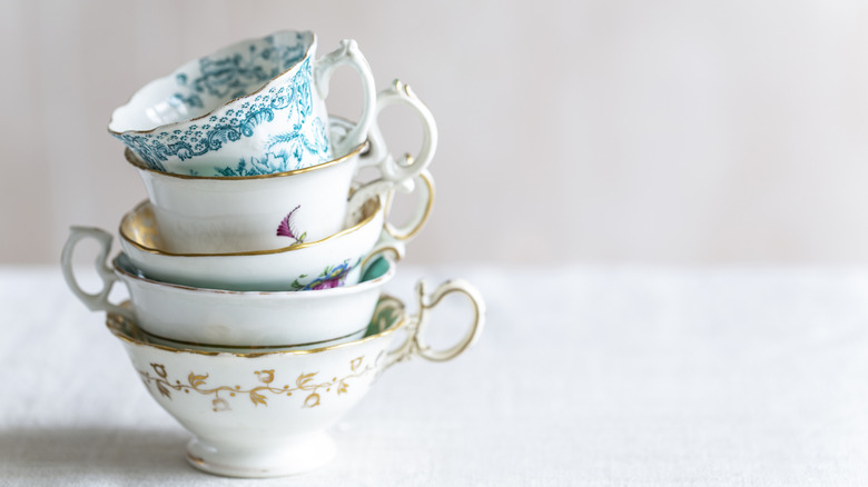 A stack of vintage tea cups on a white background