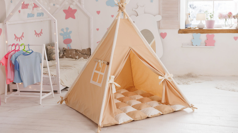 A soft beige and cream indoor teepee for a child's bedroom