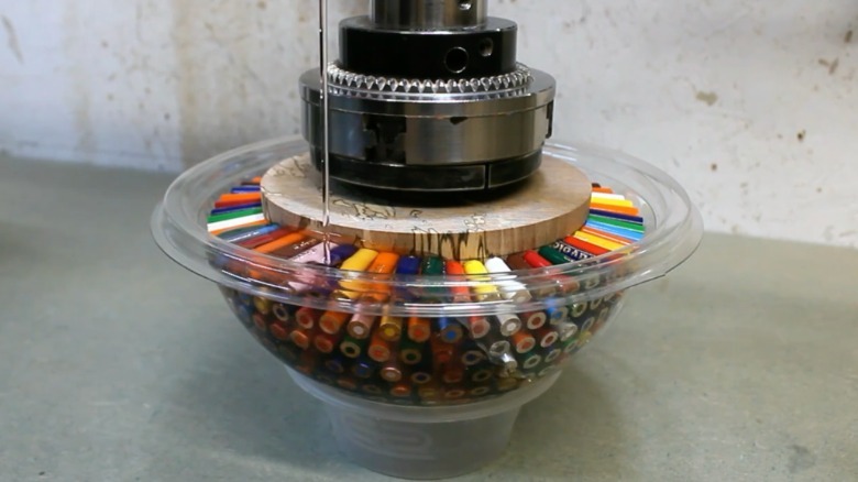 Video showing a person adhering colored pencils to a wooden ball