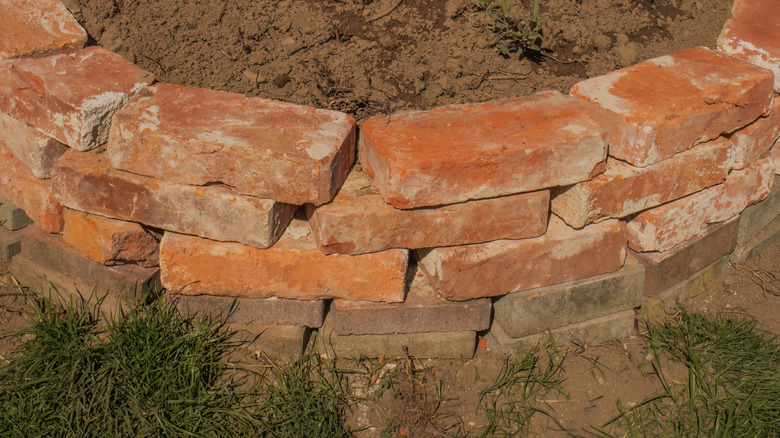 Bricks laid in an overlapping circular pattern, filled with dirt.