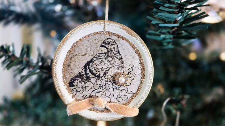 Christmas ornament made from a canning lid hanging on a tree