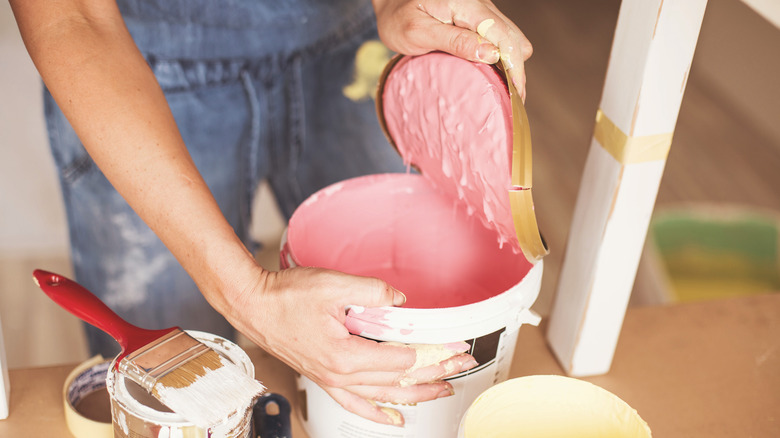 woman opening pink paint can