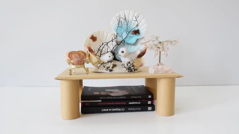 DIY shelf built with cardboard and toilet paper rolls on a plain white counter