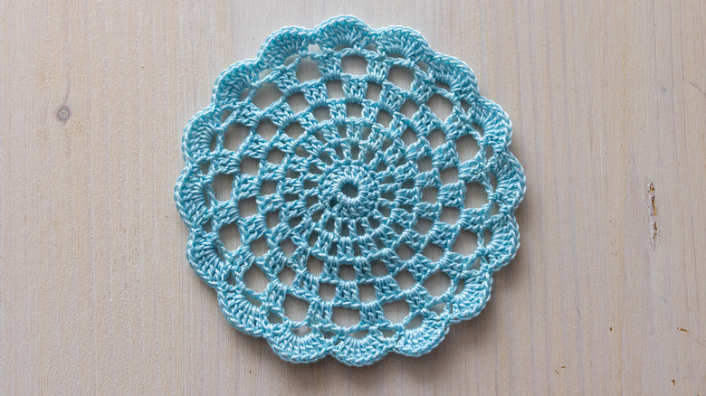 A light blue doily on an unfinished wood backdrop.