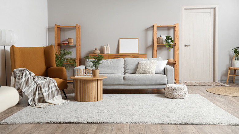 Living room with gray flooring, sofa, and wood furniture