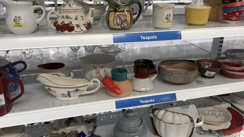 Two shelves of various vintage teapots.