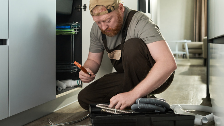 A man reaching into a portable toolbox