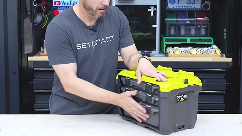 Man opening Ryobi's 3-drawer portable tool box hung on the LINK track