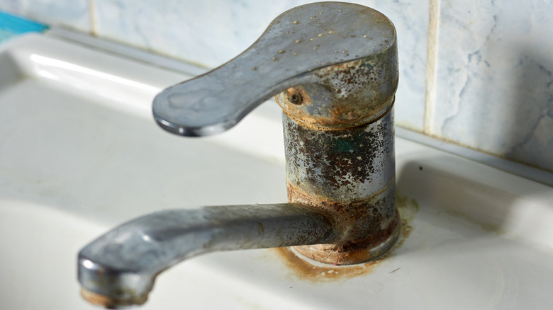 A sink faucet with a buildup of limescale