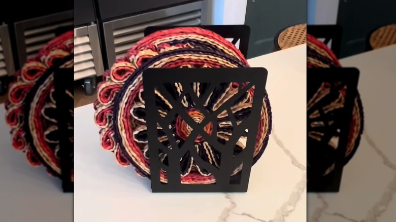 metal bookends hold a stack of trivets neatly on the counter