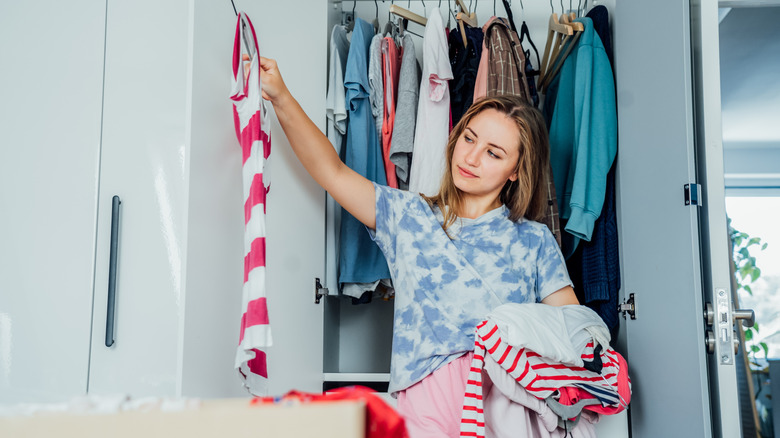 Woman sorting through the clothes in her closet