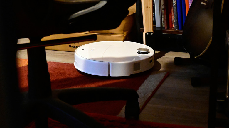 The Roborock Qrevo Edge 3 Pro robot vacuum and mop cleaning on laminate flooring and an area rug