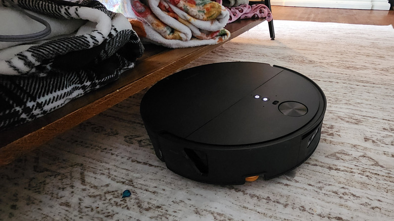The Saros 20 Flow emerging from under a coffee table on a white rug
