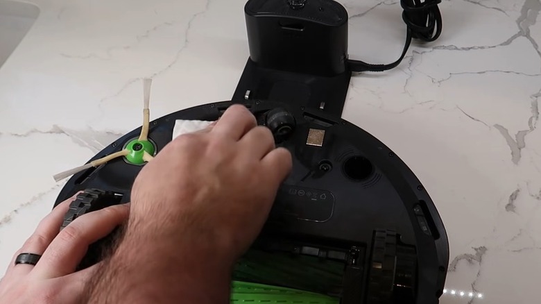 Hand cleaning the charging point with a sponge on a Roomba