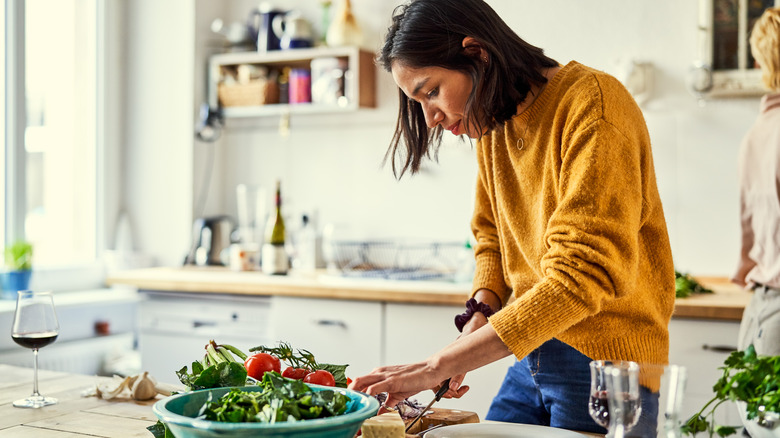 Woman in a yellow sweater preparing ingredients