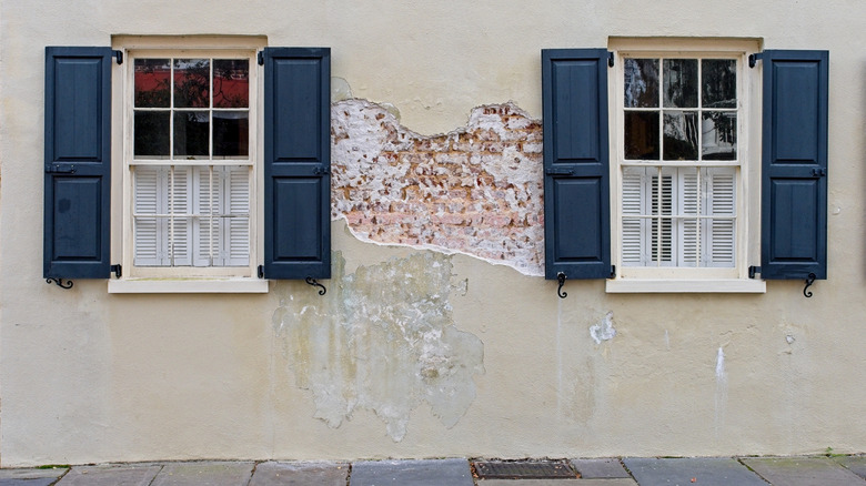 House with crumbling stucco on the exterior
