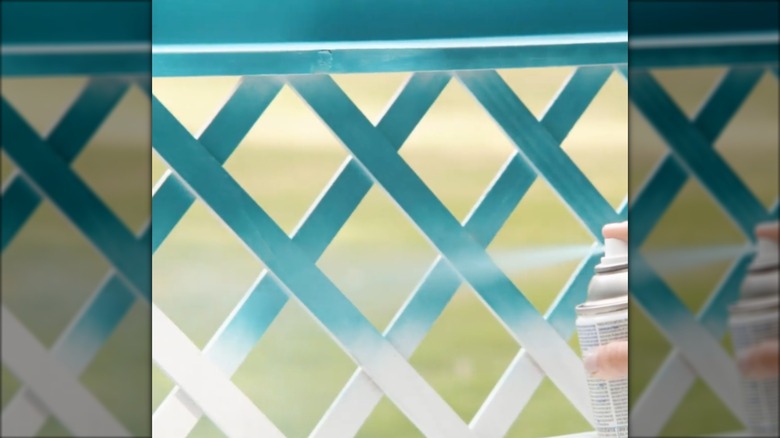 someone spraying a trellis with Satin Lagoon spray paint