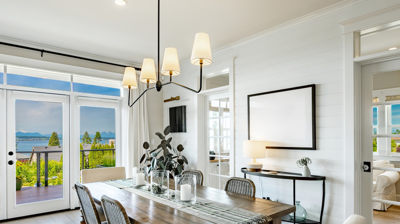 A dining room with a metal chandelier light fixture