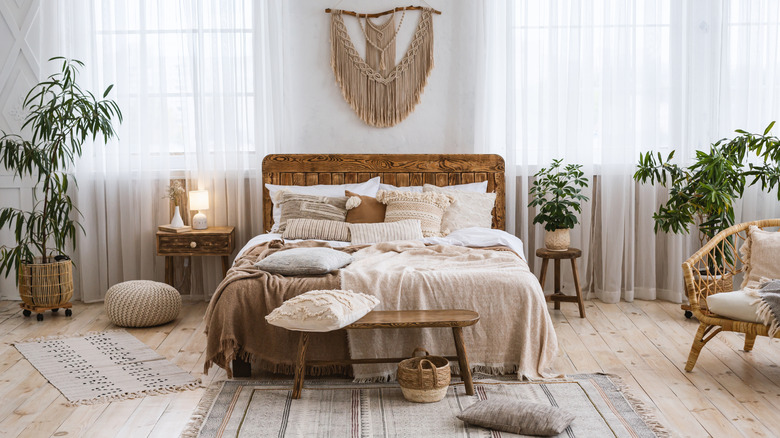 A bedroom with rustic elements like a woven wall art piece, baskets, and textured textiles.