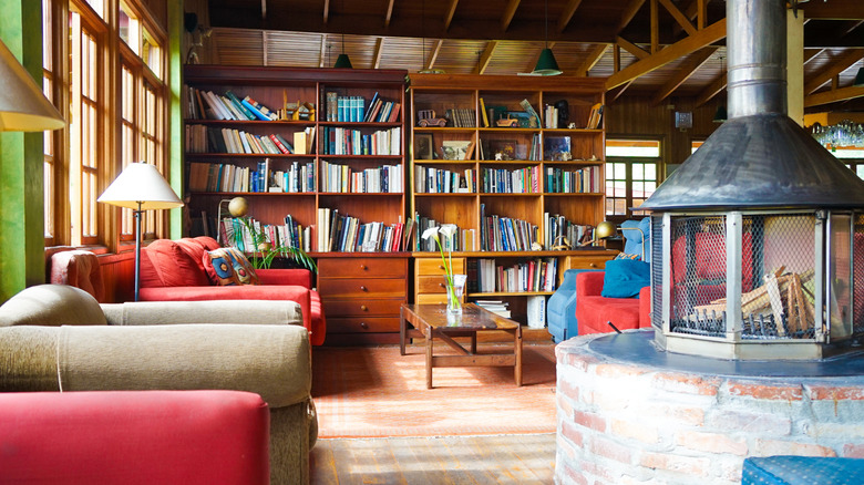 A room with oversized bookcases and a radial fireplace.