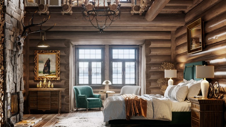 A rustic bedroom with antique furniture, log walls, and stone fireplace.